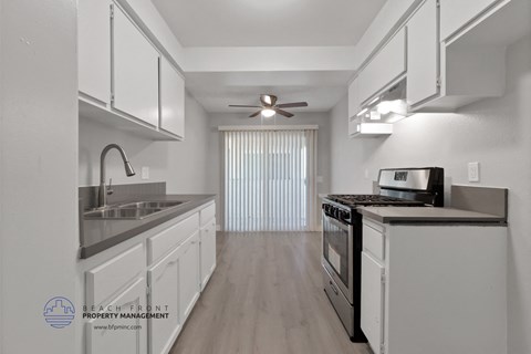 the kitchen of an apartment with white cabinets and stainless steel appliances